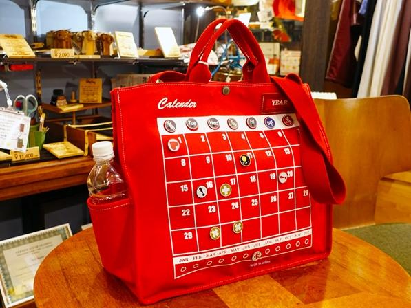 カレンダーがデザインされたトートバッグ。 ピンバッジをつけて万年カレンダーに。